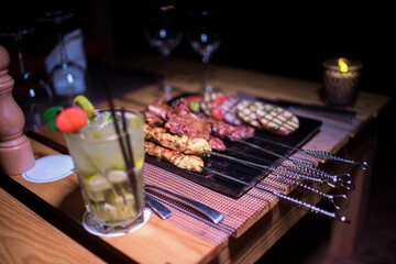 A plate of Chicken and beef BBQ with grilled tomatoes, potatoes and onions 