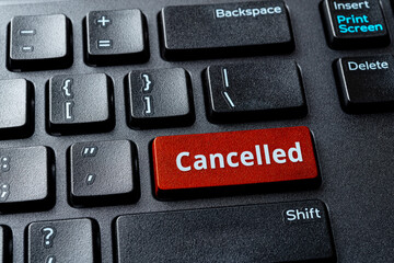 Canceled word on a red enter key of the black pc keyboard. Concepts of cancel culture, ostracism and call-out culture social media and in the Internet. Computer enter key with message. - obrazy, fototapety, plakaty