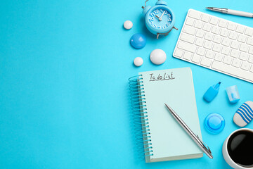 Flat lay composition with unfilled To Do list, computer keyboard and cup of coffee on light blue...
