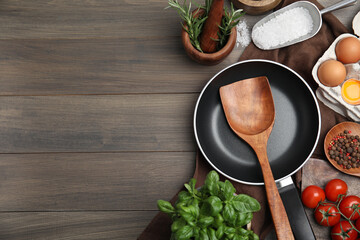 Flat lay composition with cooking utensils, frying pan and fresh ingredients on wooden table. Space...