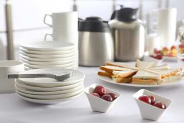 Table with different delicious snacks and dishware indoors. Coffee break