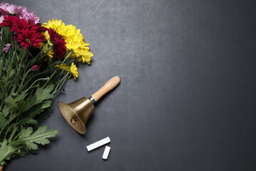 Golden school bell, bouquet of beautiful chrysanthemum flowers and chalk on blackboard, flat lay....