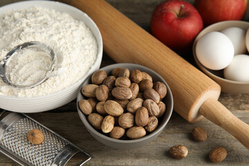 Nutmeg seeds and other ingredients for pastry on wooden table, above view