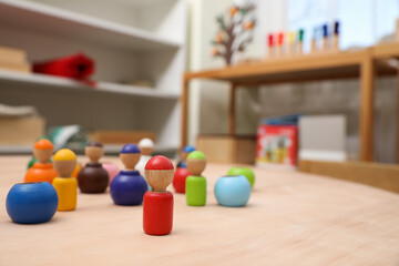 wooden colorful dolls shaped building blocks on table in room. Montessori toy - obrazy, fototapety, plakaty