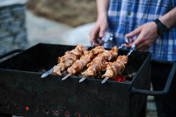 A man fries a barbecue of meat on coals. Grilled meat on coals. Chicken BBQ.