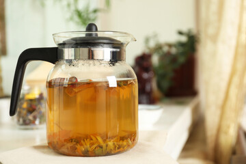 Freshly brewed herbal tea on table indoors, space for text