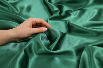 Woman touching smooth silky fabric, closeup view