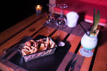 Small portion of onion rings with a cold cocktail drink beside it