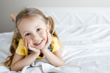 cute little girl at home in bed smiling