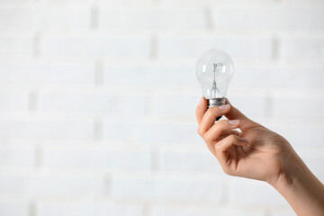 Woman holding light bulb on white background, closeup. Space for text