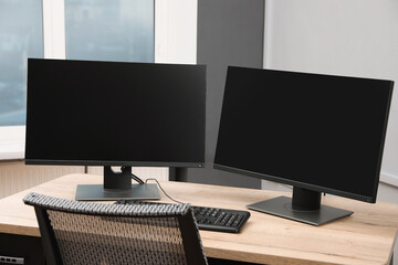 Modern interior. Workplace with multi-monitor on wooden desk in office, space for text