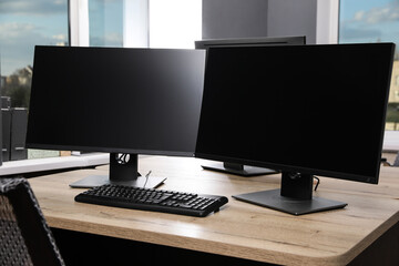 Modern interior. Workplace with multi-monitor on wooden desk in office, space for text