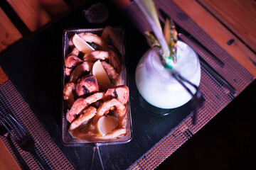 Small portion of onion rings with a cold cocktail drink beside it