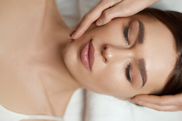 Face massage. Beautiful of young woman getting spa massage treatment at beauty spa salon.Spa skin...