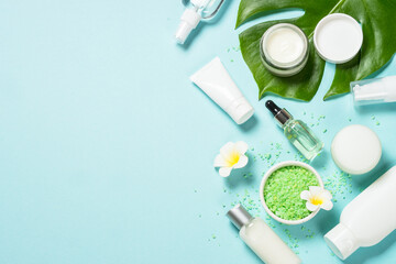 Natural cosmetic products, spa background at blue. Cream, mask, lotion and sea salt. Top view image with copy space.