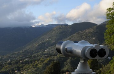 Binocolo che sorveglia una vista panoramica di montagne toscane