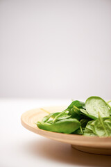 Fresh spinach on wooded plate copy space