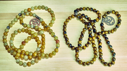 Mala beads seeds necklace on a wooden background as symbols of spiritual growth and of overcoming obstacles on the path to enlightenment. color