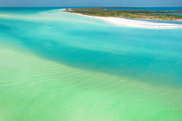 Blue - turquoise color of ocean salt water. Panorama of island. Summer vacation. Florida beach. Beautiful Paradise. Ocean or Gulf of Mexico. Tropical Nature. Aerial view. 