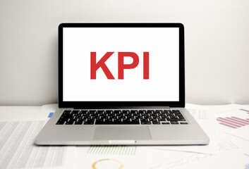 KPI acronym Business team hands at work with financial reports and a laptop