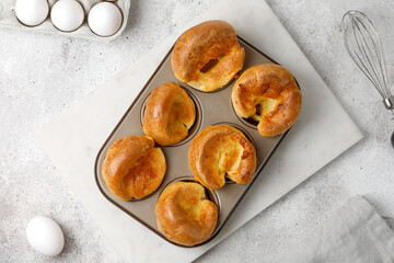 Traditional English Yorkshire pudding in baking dish, in muffin cups. Homemade food. Grey background