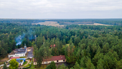 Fototapeta na wymiar Aerial view of luxury hotel with villas in forest. Luxurious villa, pavilion in forest. Resort complex in forest surrounded by trees.