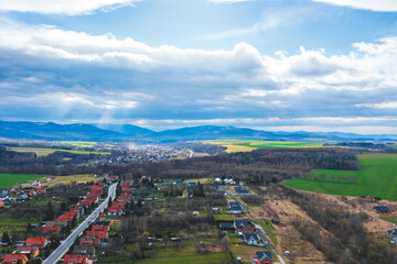 Village landscape from above, aerial view of private rural houses among green fields and mountains