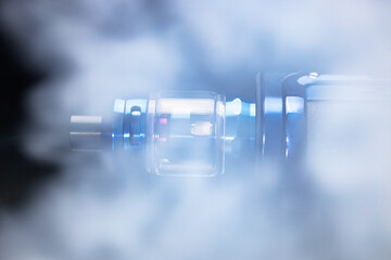 Electronic cigarette in smoke on a black background, smoking nicotine through an electronic...