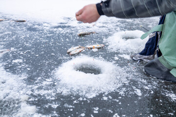 Fisherman changing bait on ice fishing, frozen hands on ice fishing