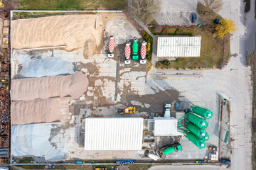 Aerial view of asphalt plant, concrete mixing plant and large piles of sand with crushed stone