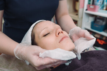 Obraz na płótnie Canvas Cosmetologist apply facial treatment on woman face in beauty saloon. Skincare. Cosmetic procedure.