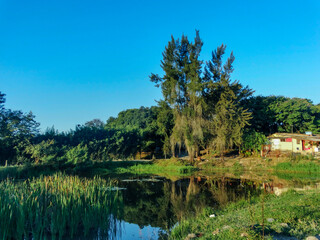 Fototapeta na wymiar Fazenda, com lindo lago artificial, muita vegetação e montanhas ao redor, localizada na região rural do bairro Jardim das Oliveiras, município de Esmeraldas, Minas Gerais, Brasil.