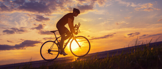 Young sports man cycling with bicycle on the road in summer - 502838618