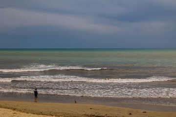 Fototapeta na wymiar serene landscape of a woman on the shores of the blue sea