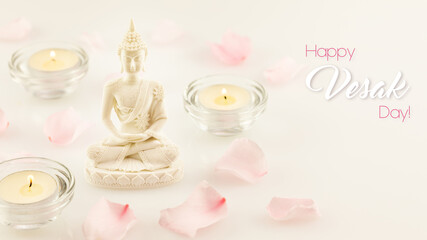 Vesak holiday card wwith Buddha statue, rose petals and candles