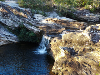 Pequena Cachoeira entre muitas rochas e vegetação em volta, localizada na região rural de Três Barras, município do Serro, Minas Gerais, Brasil.
