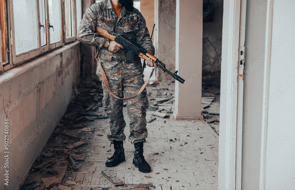 Wall mural Soldiers in camouflage with a military weapon