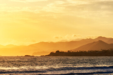 Naklejka na ściany i meble Sunset, sunrise over the ocean, waves, mountains