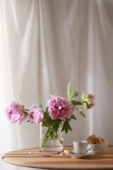 Cup of coffee, cookies and bunch of peony flowers on wooden table. Copy space