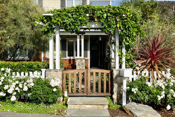 front view of beach house with vine covered pergola and front gate