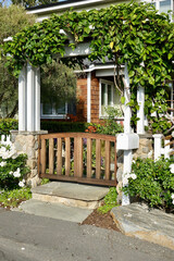 beach house with gated pergola entryway to the garden