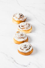 Cinnamon buns with delicate cheese cream. Light background
