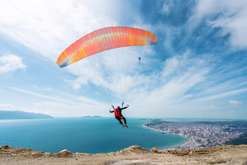 Paraglider is starting. Parachute is filling with air in the mountains alps on a sunny day in...