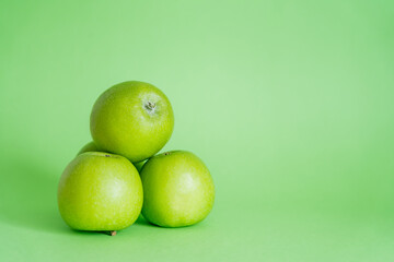 whole and fresh apples on green background.