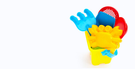 Plastic toys, shovels in bucket for sand on white background. Summer background concept