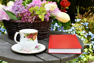 Spring garden afternoon tea with lilacs and tulip bouquet in beautiful garden setting