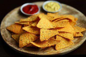 Corn chips nachos with sauces on a wooden board. Mexican snack.