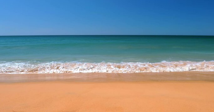 Empty beach with perfect clean sand coast. Waves break of ocean shore