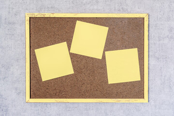 Trois post-it jaunes sur petit tableau en bois