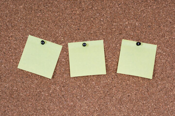 3 post-it jaunes épinglés sur tableau en liège
